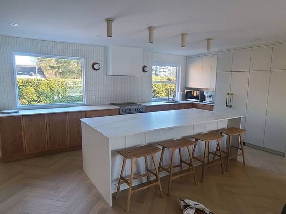 Cuisine blanche avec grand îlot et tabourets